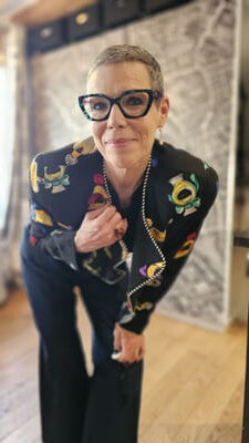 Hallway of FAshion smiling at camera in vintage jacket