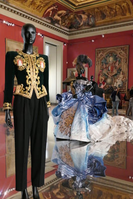 embroidered pant suit on mannequin in front of ballgown on mannequin