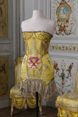 a yellow silk embroidered dress on a mannequin